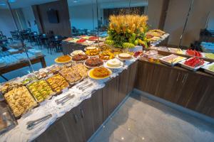 a buffet line with many different types of food at Brisa Tower Hotel in Ceilândia