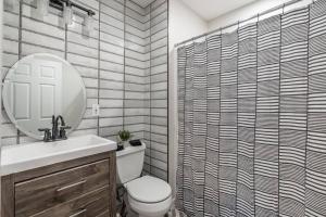 a bathroom with a toilet and a sink and a mirror at Rockwell Playce- Bold, Stylish & Great Location in Atlantic City +45 photos