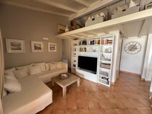 a living room with a couch and a tv at Villa Carlotta in San Teodoro