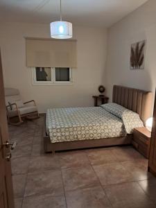 sypialnia z łóżkiem i oknem w obiekcie ILIANA.APARTMENTS w Kardamenie