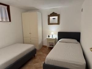 a small bedroom with two beds and a cabinet at Villa Carlotta in San Teodoro +25 photos