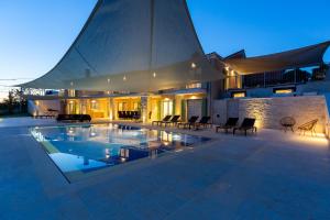 a house with a swimming pool in front of a building at Villa Panorama Poreč in Mugeba +59 photos