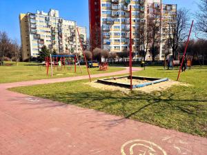 an empty playground in a park with a building at Apartament Balladyny in Lublin