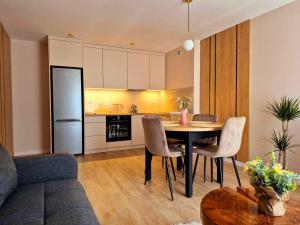 a kitchen and living room with a table and chairs at Apartament Balladyny in Lublin