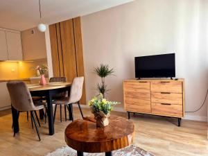 a living room with a table and a television on a dresser at Apartament Balladyny in Lublin