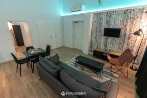 a living room with a couch and a table at Paradisier in Villars-les-Dombes