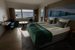 a hotel room with a bed and a table and chairs at Hotel Arctic in Ilulissat