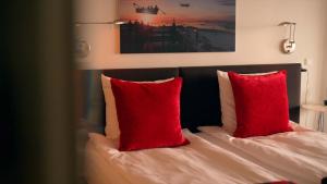 a bedroom with a bed with red pillows at Hotel Arctic in Ilulissat