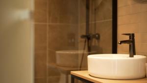 a bathroom sink with a faucet and a shower at Hotel Arctic in Ilulissat