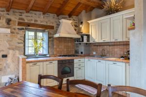 a kitchen with white cabinets and a table and a stove at Rifugio Ca' da Cardella in Mendatica