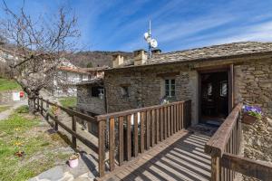 a small stone house with a wooden deck at Rifugio Ca' da Cardella in Mendatica