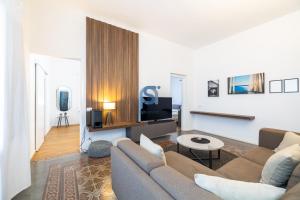 a living room with a couch and a tv at Ni Ni Apartments - Self Check in in Cefalù