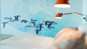 a flock of birds flying in the air at Hotel Arctic in Ilulissat