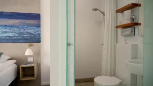 a bathroom with a shower and a toilet and a sink at Hotel Arctic in Ilulissat