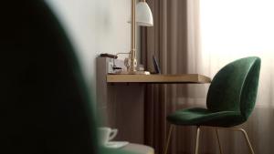 a desk with a green chair and a lamp at Hotel Arctic in Ilulissat