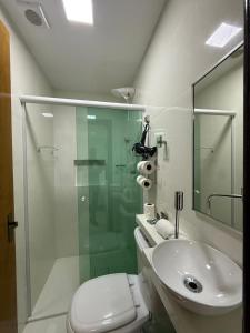 a bathroom with a shower and a toilet and a sink at Hotel Paraiso Go in Valparaíso de Goiás