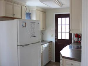 cocina con nevera blanca y armarios blancos en Ocean Block Internetwifi Deck Washer & Dryer Well-Maintained First Floor Unit Of An Ocean Block Duplex Great Location, Just One House Between, en Peahala Park