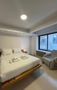 a bedroom with a large white bed with a window at Mosaikon Guesthouses #Vasilikis Str in Athens
