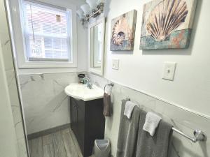 un baño con lavabo y espejo en Buoy Bay–Waterfront Luxury in AC | Relax & Unwind!, en Atlantic City 73 fotos más