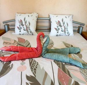 2 cygnes assis au-dessus d'un lit dans l'établissement Domaine Mare e Monti - T2 Les Mimosas, à Albitreccia