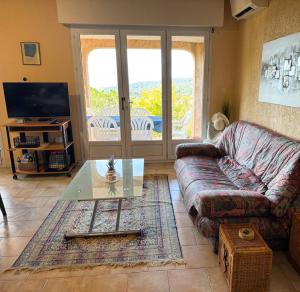 un salon avec un canapé et une table en verre dans l'établissement Domaine Mare e Monti - T2 Les Mimosas, à Albitreccia