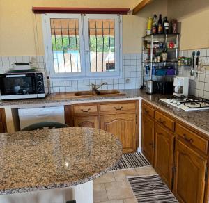 une cuisine avec des armoires en bois et un comptoir dans l'établissement Domaine Mare e Monti - T2 Les Mimosas, à Albitreccia 10 autres photos