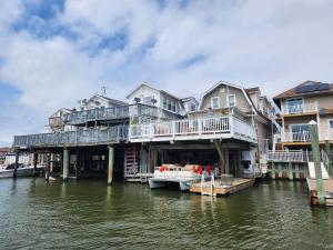 una casa grande con un barco en el agua en Buoy Bay–Waterfront Luxury in AC | Relax & Unwind!, en Atlantic City