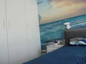 a bedroom with a painting of the ocean at Bursztynowy Brzeg - Mechelinki Revital in Mechelinki +30 photos