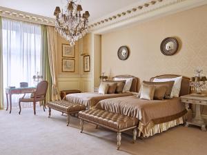 a bedroom with two beds and a chandelier at Grand Hotel Wien in Vienna