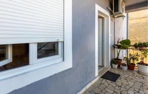 a window on the side of a house with potted plants at Awesome Apartment In Novi Vinodolski in Novi Vinodolski +16 photos