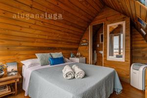 Un dormitorio con una cama con toallas. en Cabaña Maldivas con vista - Pousada Sunset View, en Praia do Rosa 8 fotos más