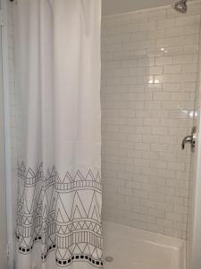 e bagno con doccia con tenda bianca. di Run-AC Villa- Block from Ocean Casino & Waterpark! ad Atlantic City Altre 33 foto