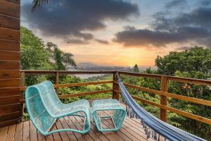 una hamaca y una silla en una terraza con vistas en Cabaña Maldivas con vista - Pousada Sunset View, en Praia do Rosa