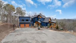una casa azul en el bosque con entrada en Blue Fox Lodge, en Blue Ridge