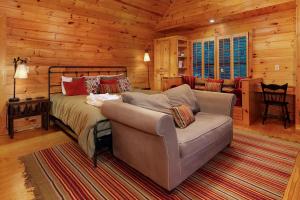 a bedroom with a bed and a couch at Cartacay River Retreat - North Georgia Riverfront Cabin - Riverside access, cozy living spaces, game room, and outdoor amenities in Ellijay
