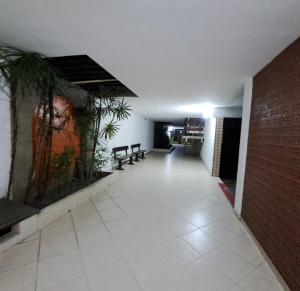 a hallway with benches and plants in a building at Quarto da Orla in Cabo Frio