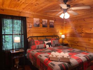 a bedroom with a bed in a log cabin at Dancing Bear - Cherry Log GA - Dog Friendly Cabin - Mountain Views, Hot Tub, Wood-Burning Fireplace - 15 Minutes to Downtown Blu in Blue Ridge