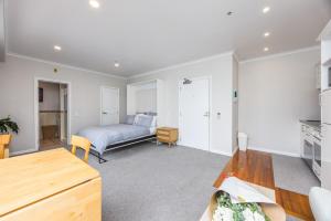 a living room with a bed and a table at Princes Wharf with HUGE deck!! in Auckland