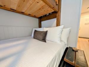 a bedroom with a white bed with a wooden ceiling at Purcell Condos by StayIn in Kimberley +18 photos