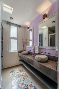 a bathroom with two sinks and a large mirror at Casa Lila in Mérida