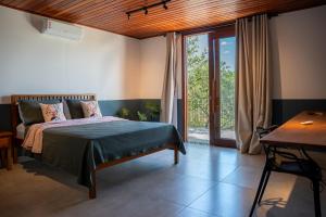 a bedroom with a bed and a large window at Casa Canto do Bem-te-vi in Lençóis