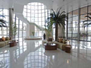 a lobby with couches and plants in a building at Novotel Abu Dhabi Gate in Abu Dhabi