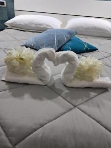 a bed with towels and flowers on it at La Petite Maison in Naples