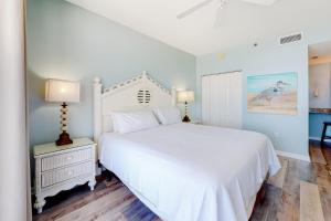 a bedroom with a white bed and a white dresser at The Beach Club 1101C in Gulf Highlands +40 photos