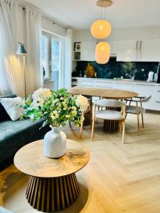 a living room with a couch and a table with flowers at Spacious boutique family apt w sunny balcony & mountain views in Zell am See