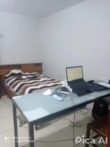 a desk with a laptop computer on it next to a bed at Peruvian Apartment in Lima