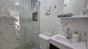 リオデジャネイロにあるLoft aconchegante na praia do Recreioのトイレと洗面台を備えた白いバスルーム