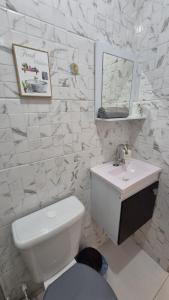 リオデジャネイロにあるLoft aconchegante na praia do Recreioのトイレと洗面台を備えた白いバスルーム