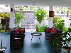 a patio with two couches and a table and a wall at La Villa Saint Jean in Cotonou
