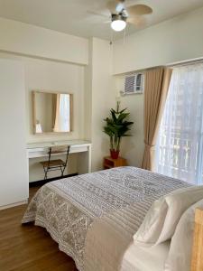 una camera da letto con un letto, uno specchio e una finestra di 5 Star Luxury Condo - Metro Manila a Manila